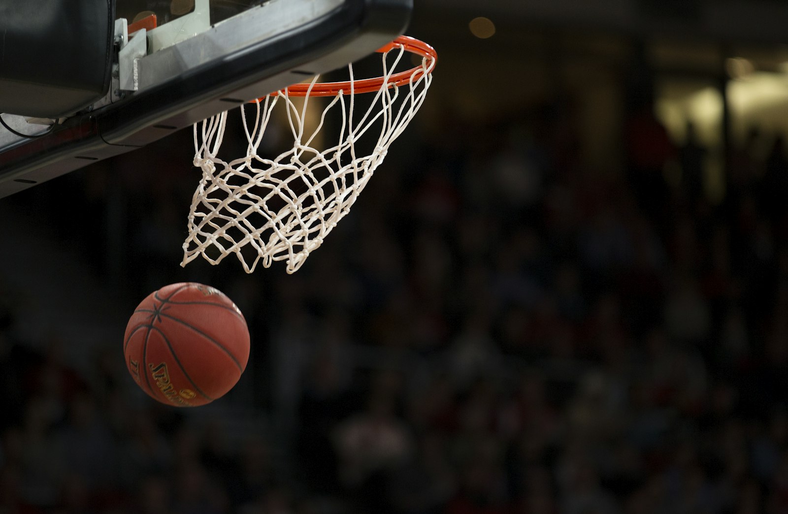 Basketball dropping through the net of a hoop in an arena